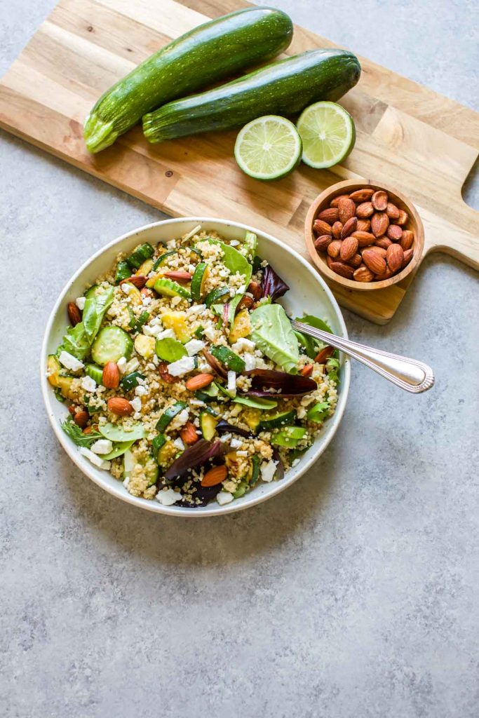 quinoa salad with zucchini , almonds and limes on the side
