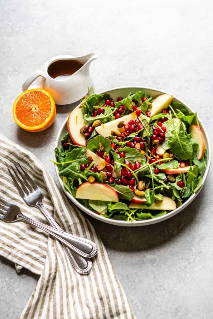 kale salad with apples and dressing on the side